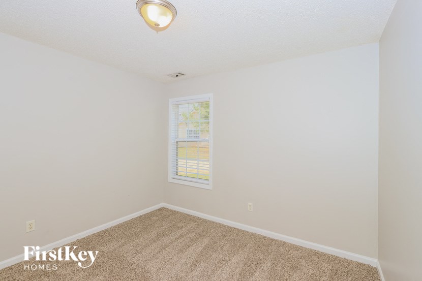 a bedroom with a carpeted floor and a window