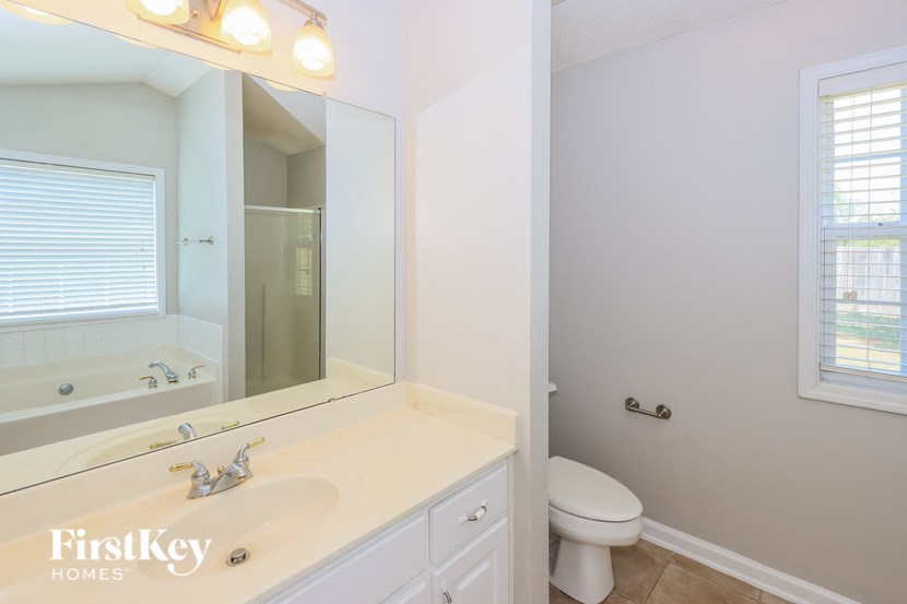 a bathroom with a sink toilet and a mirror
