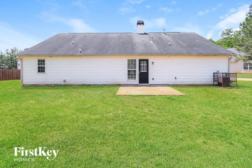 the front of a white house with a yard and grass