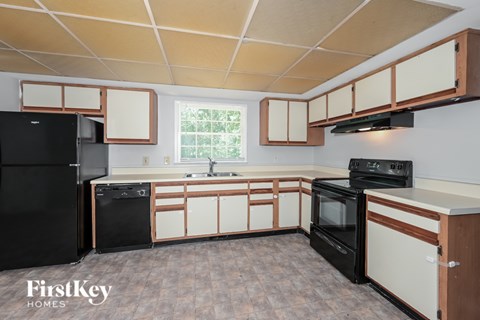 A kitchen with black appliances and white cabinets.