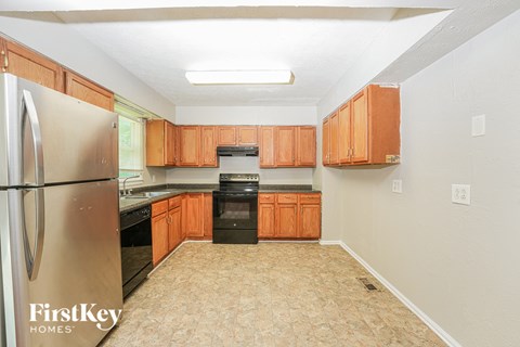 A kitchen with wooden cabinets and a stainless steel refrigerator.