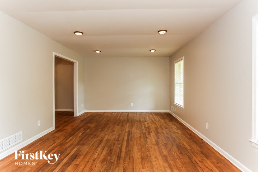 a empty living room with wooden floors and a door
