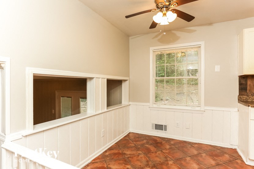 a living room with a ceiling fan and a window