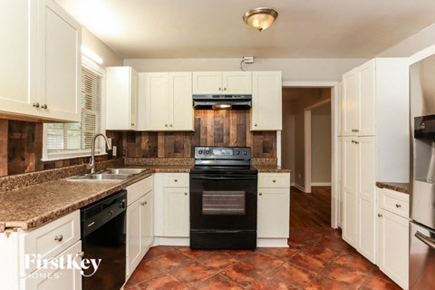 a kitchen with white cabinets and a stove and a sink
