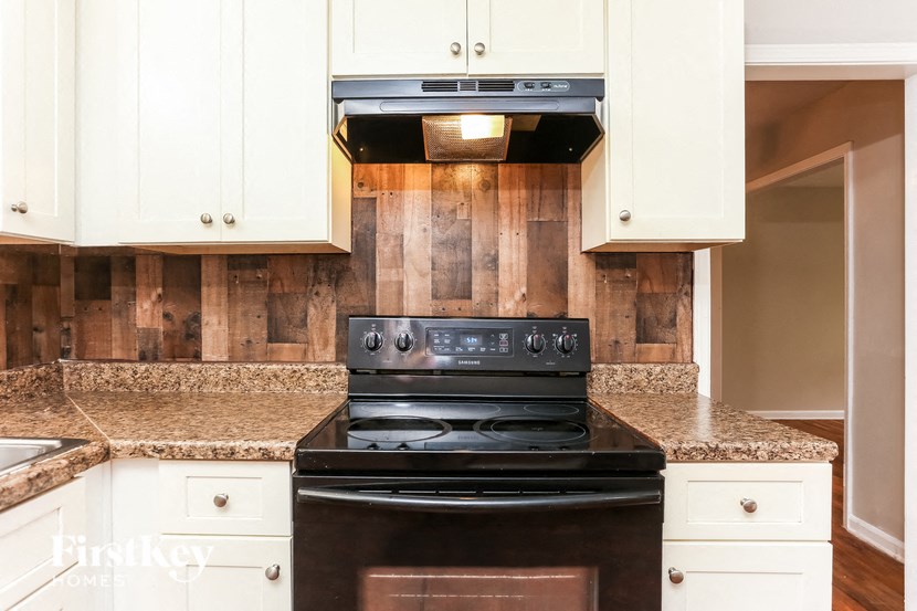 a kitchen with white cabinets and a black stove