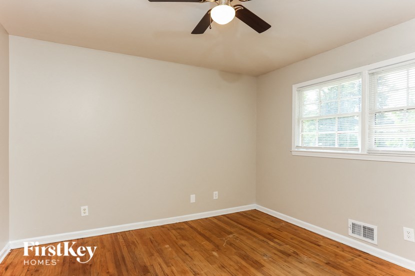 a bedroom with a ceiling fan and a wood floor