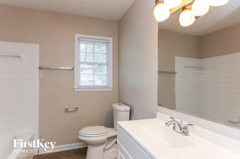 a bathroom with a toilet and a sink and a mirror