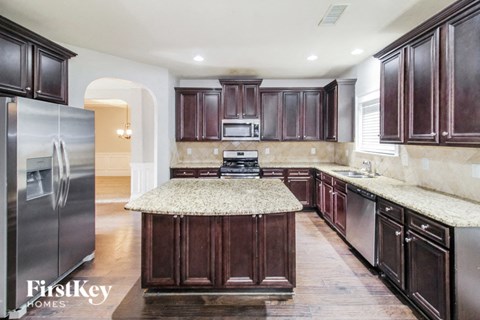 a kitchen with wood cabinets and granite counter tops and stainless steel appliances