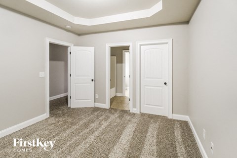 a bedroom with three doors and a carpeted floor