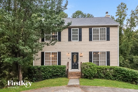 a home with black shutters and a black front door