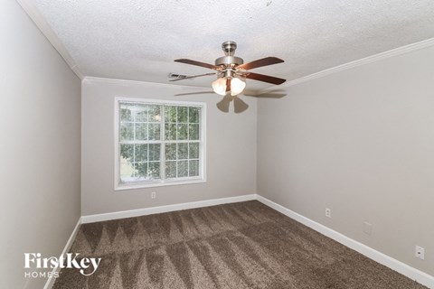 a bedroom with a ceiling fan and a window