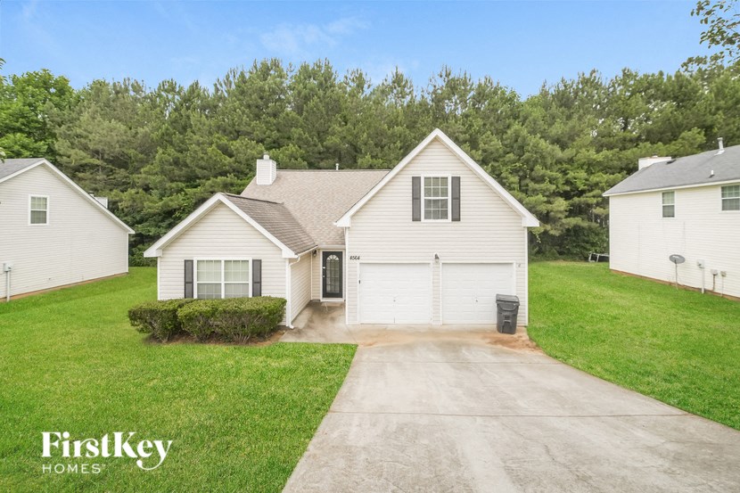 a white house with a garage and a driveway