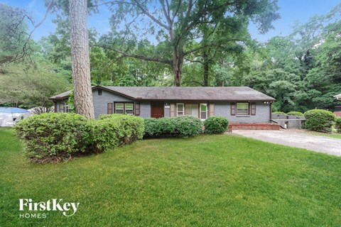 a small house with a yard and a tree