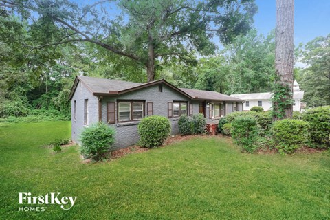 a small house with a lawn and trees