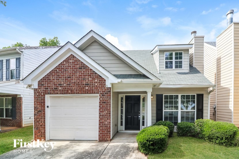 A brick house with a white garage door and a black door.