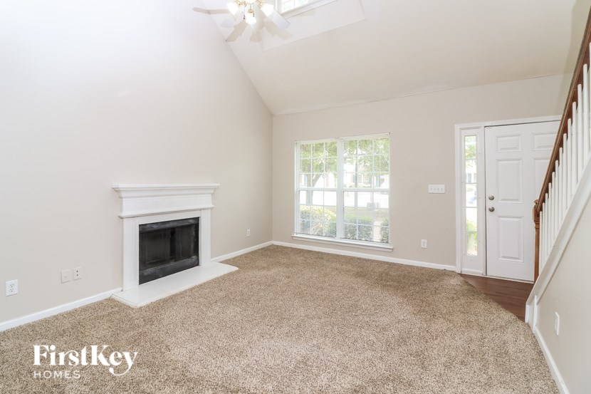 A spacious room with a fireplace and a ceiling fan.