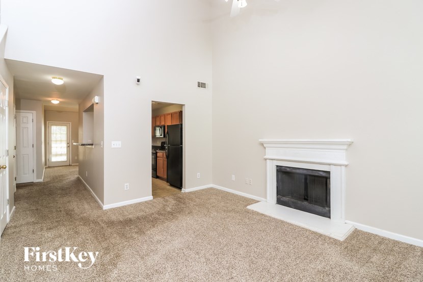 A living room with a fireplace and a carpeted floor.