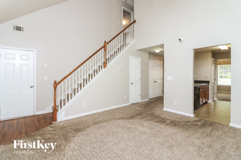 A spacious living room with a staircase leading to the upper floor.