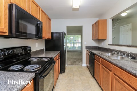 A kitchen with wooden cabinets and a black stove top oven.