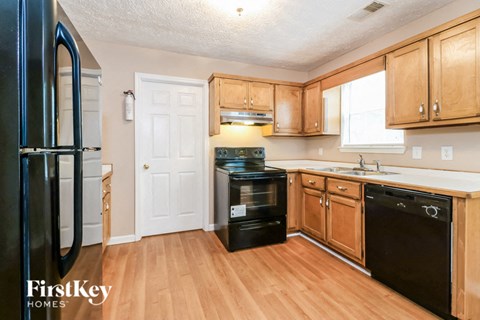a kitchen with wooden floors and black appliances