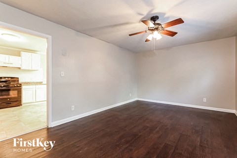 the living room of an empty house with a ceiling fan