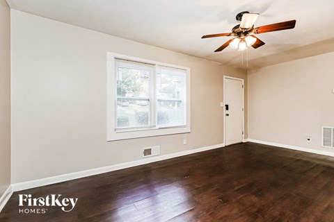 a living room with wood floors and a ceiling fan