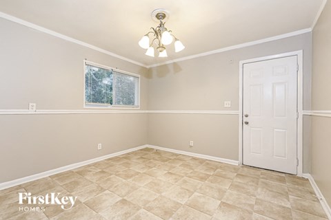 a empty room with a white door and a chandelier