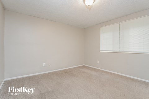 a bedroom with a carpeted floor and a large window