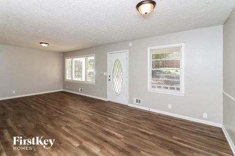 the living room of an empty house with a wooden floor
