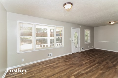 the living room of an empty house with a wooden floor