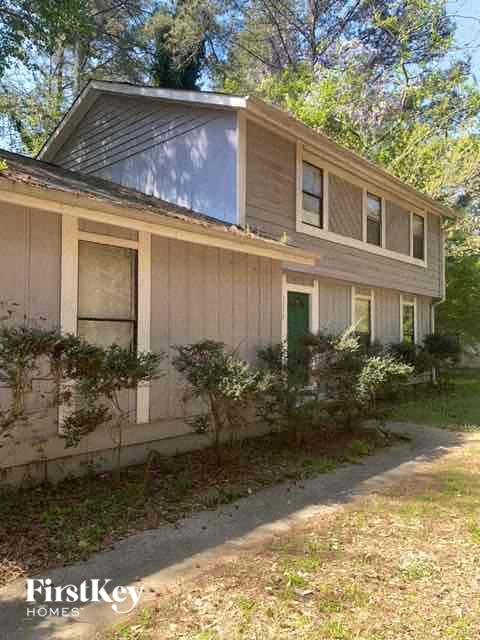 a house with a green door and a sidewalk