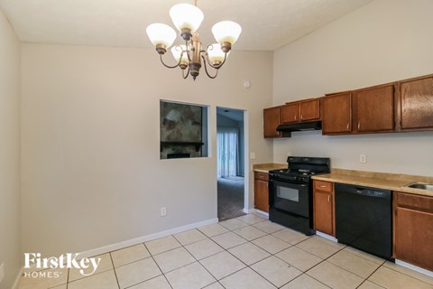 A kitchen with black appliances and wooden cabinets.