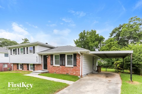 a white and brick house with a driveway and a covered porch
