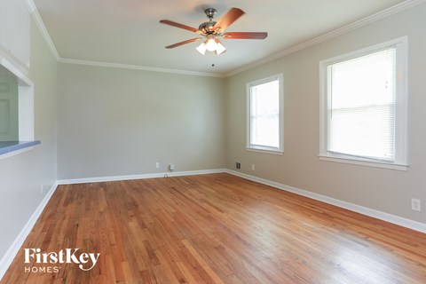 a living room with wood floors and a ceiling fan