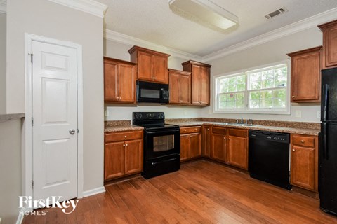 a kitchen with wooden cabinets and black appliances