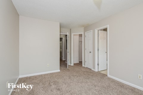 a spacious living room with white walls and carpet