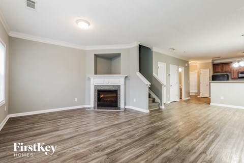 A spacious living room with a fireplace and wooden flooring.