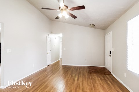 a living room with hardwood floors and a ceiling fan