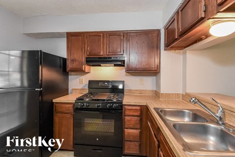 a kitchen with a stove and a sink and a refrigerator