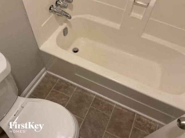 a bathroom with a bath tub and a toilet