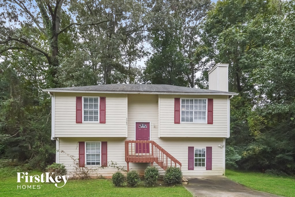 a white house with red shutters and a red door