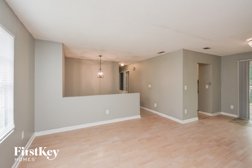 the living room and dining room of an empty house