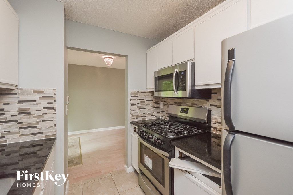 a kitchen with stainless steel appliances and white cabinets