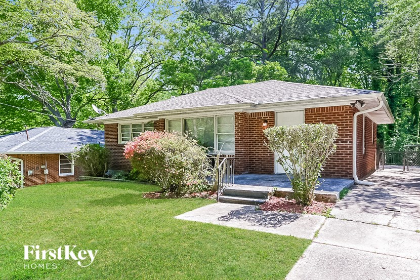 a brick house with a lawn and a porch