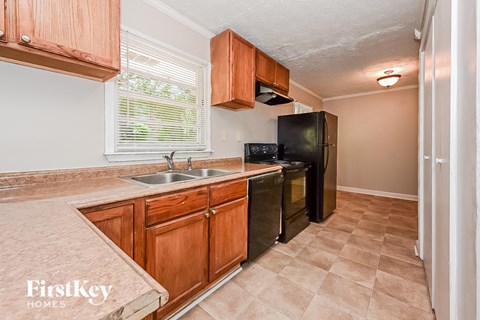 a kitchen with a sink and a black refrigerator