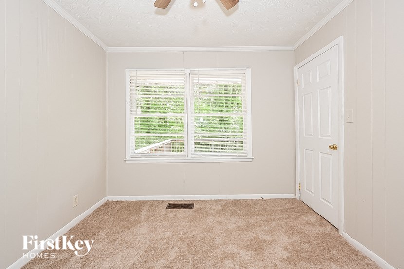 a empty room with a window and a white door
