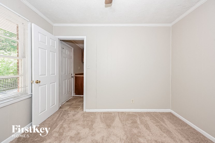 an empty bedroom with a door and a closet