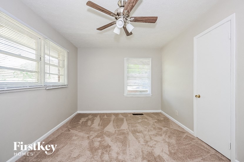 an empty room with a ceiling fan and a window