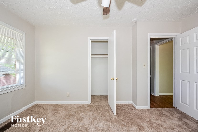 an empty bedroom with a closet and a door to a hallway