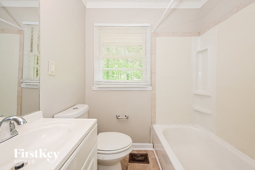 a bathroom with a toilet and a tub and a sink